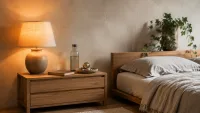 We see a calm bedroom with a compact oak bedside table beside a low platform bed.