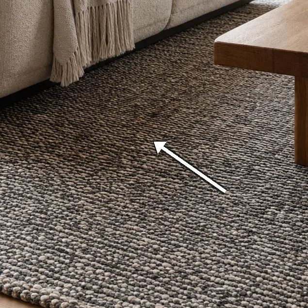Detail shot of bouclé cushions, linen throw, and teak coffee table