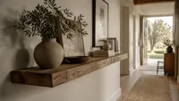 Wide hallway with a reclaimed oak floating shelf, natural daylight, and calm organisation.