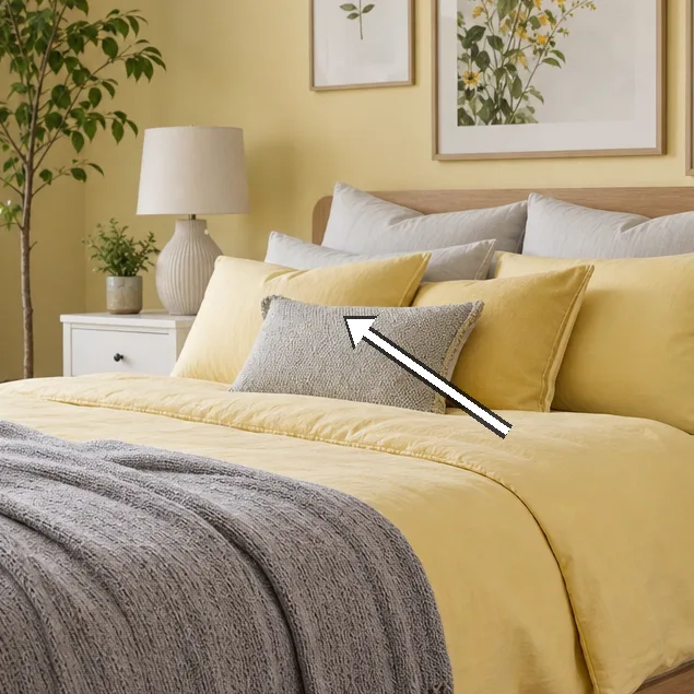 Tall indoor plant by window beside a yellow pouffe
