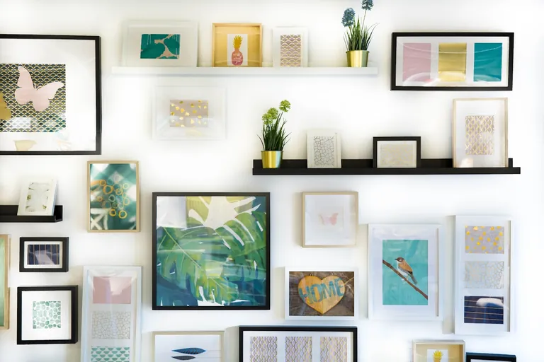 A matt-black swing-arm wall lamp mounted above a tidy bed, casting warm light across a clear bedside surface. — detail 2