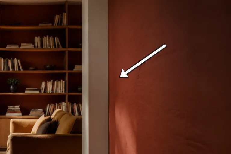 Macro of matte painted shelf back showing brush texture and warm clay tone